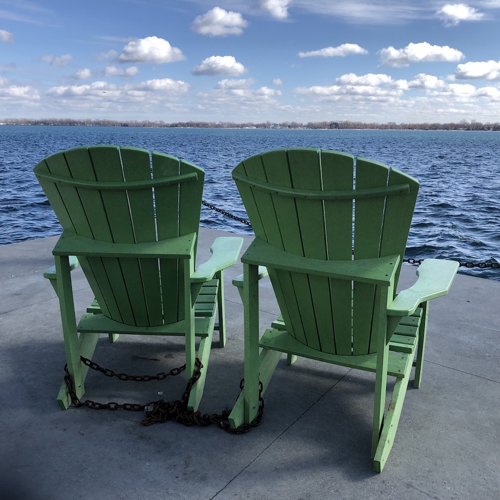 Green chairs by the lake.